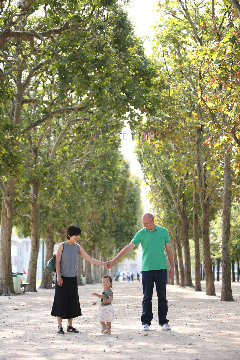 パリの公園の並木道で家族写真