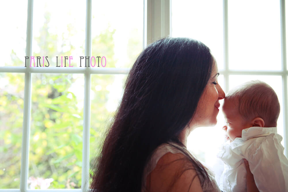 パリの自宅でママが赤ちゃんの額にキス